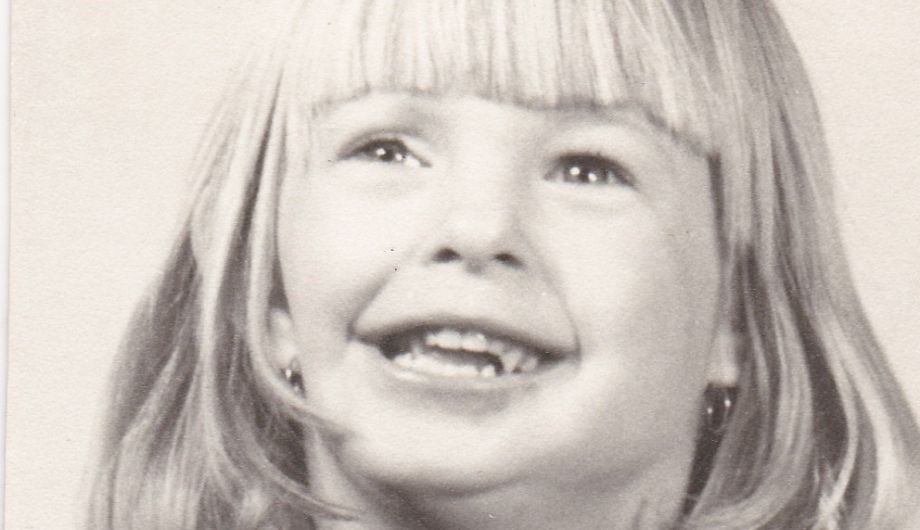 A young girl, 4 to 6 years old, with long blond hair, smiling