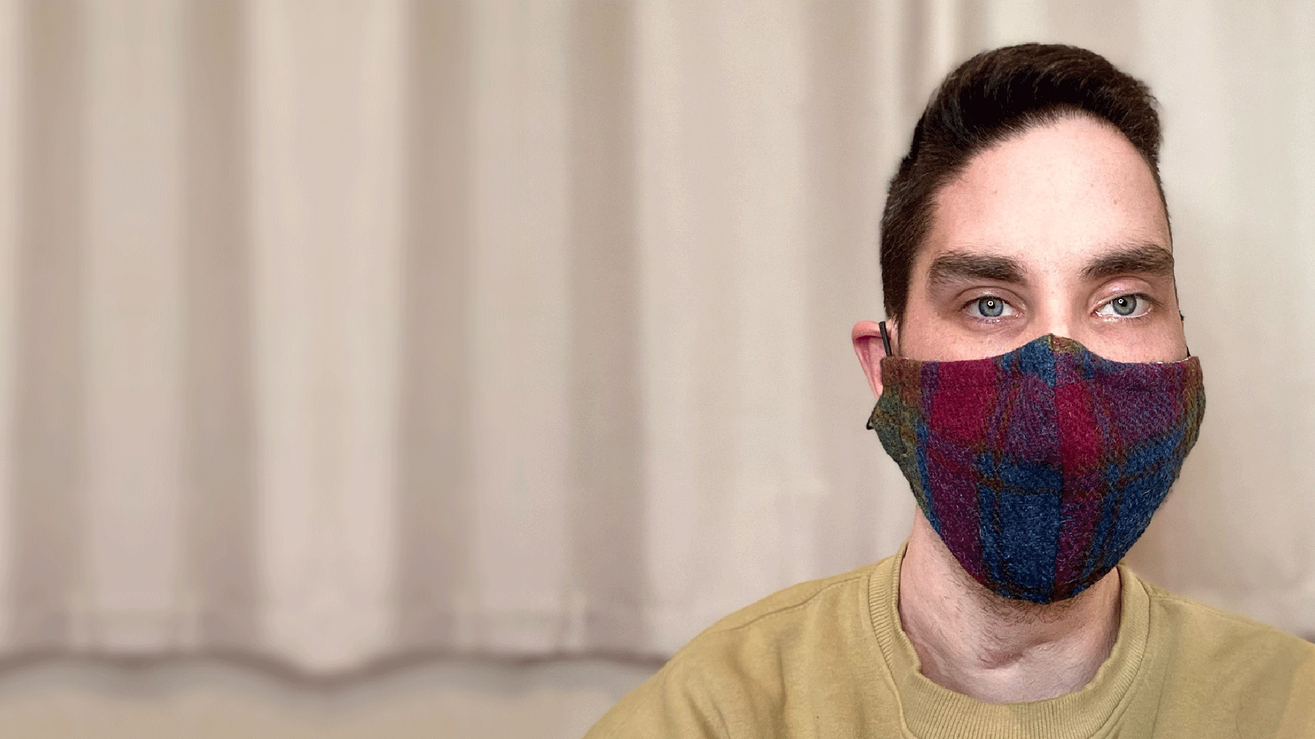 A man wearing a face mask looking directly to camera