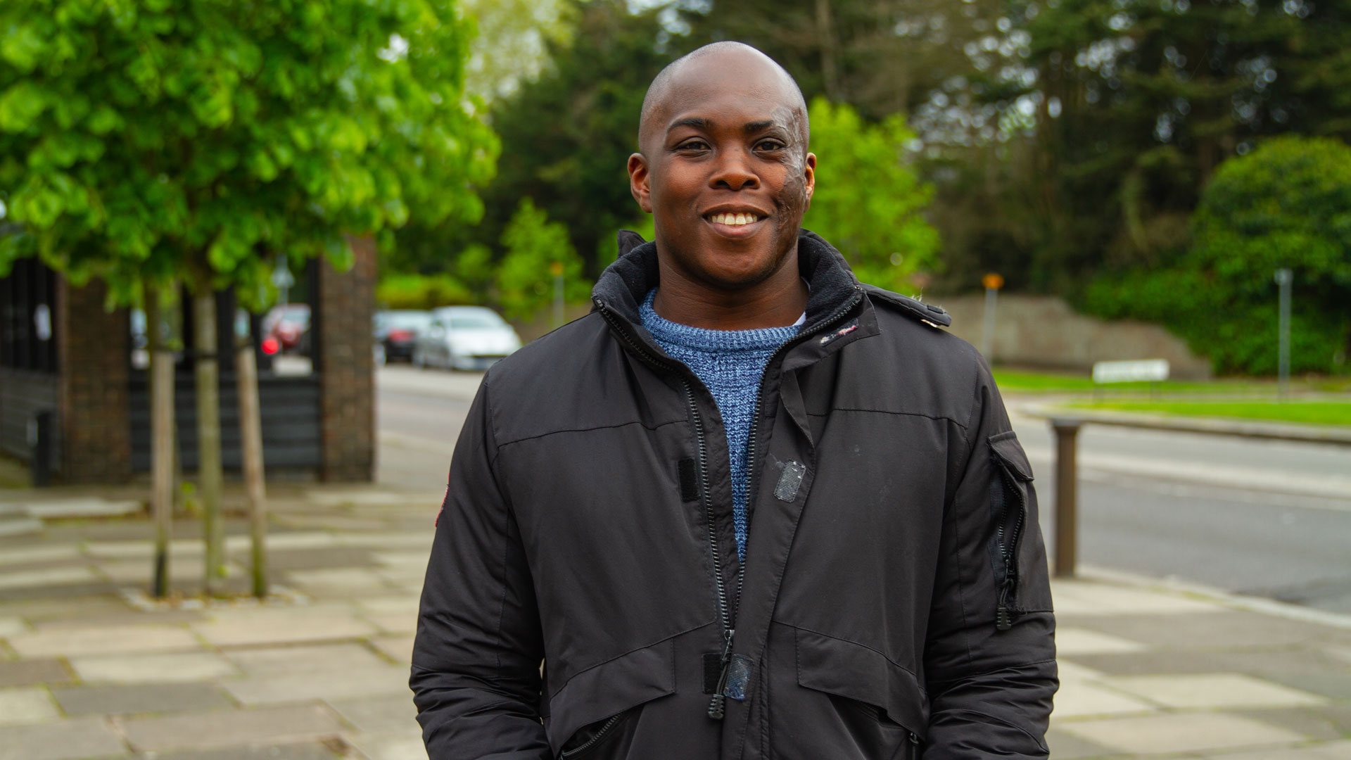 Michael smiling, standing on a quiet street