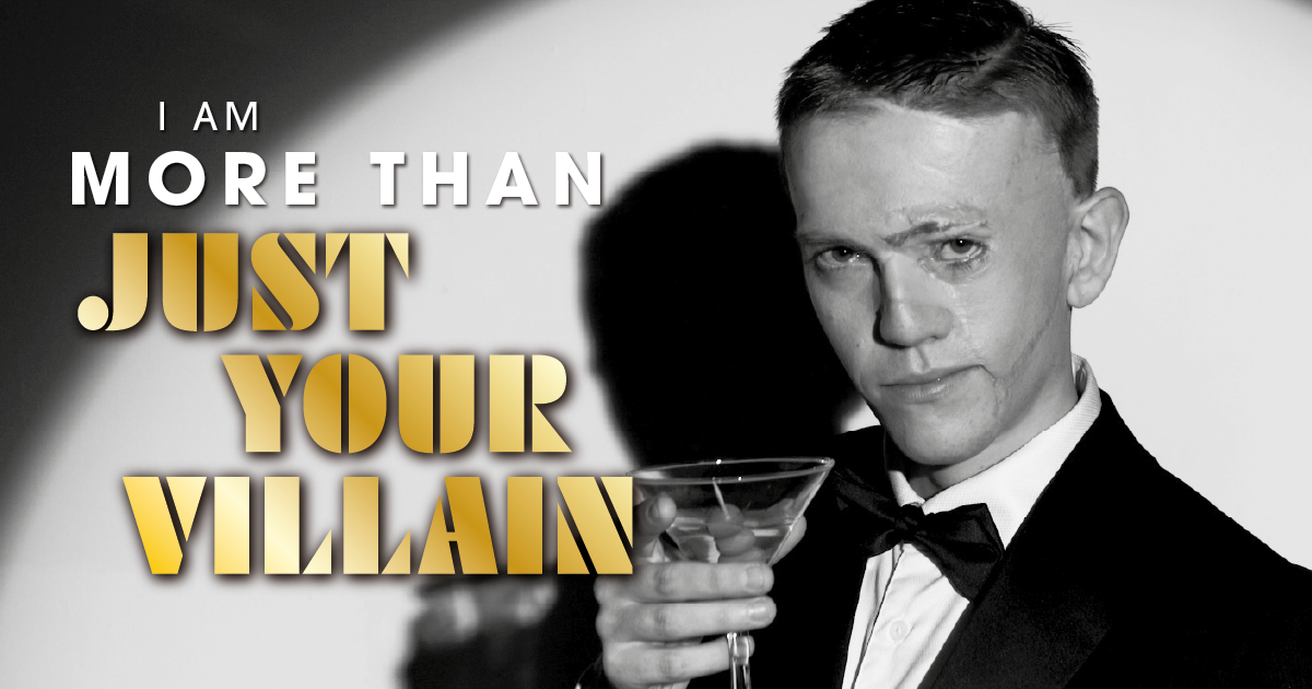 A person with a visible difference dressed as James Bond, with the test "I am more than just your villain"