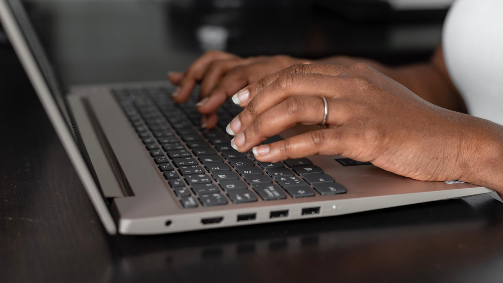 Hands typing on a MacBook keyboard
