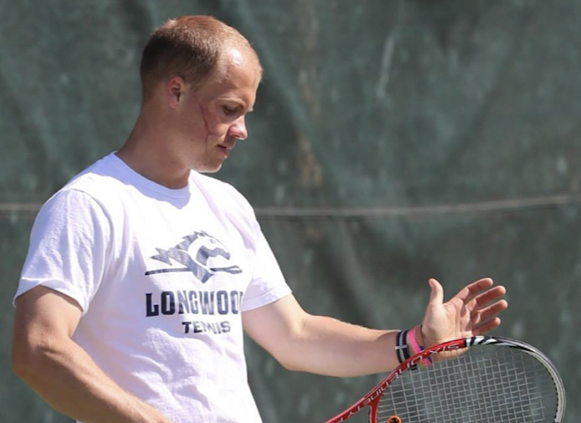 Daniel playing tennis - an action shot with his racket mid-air.