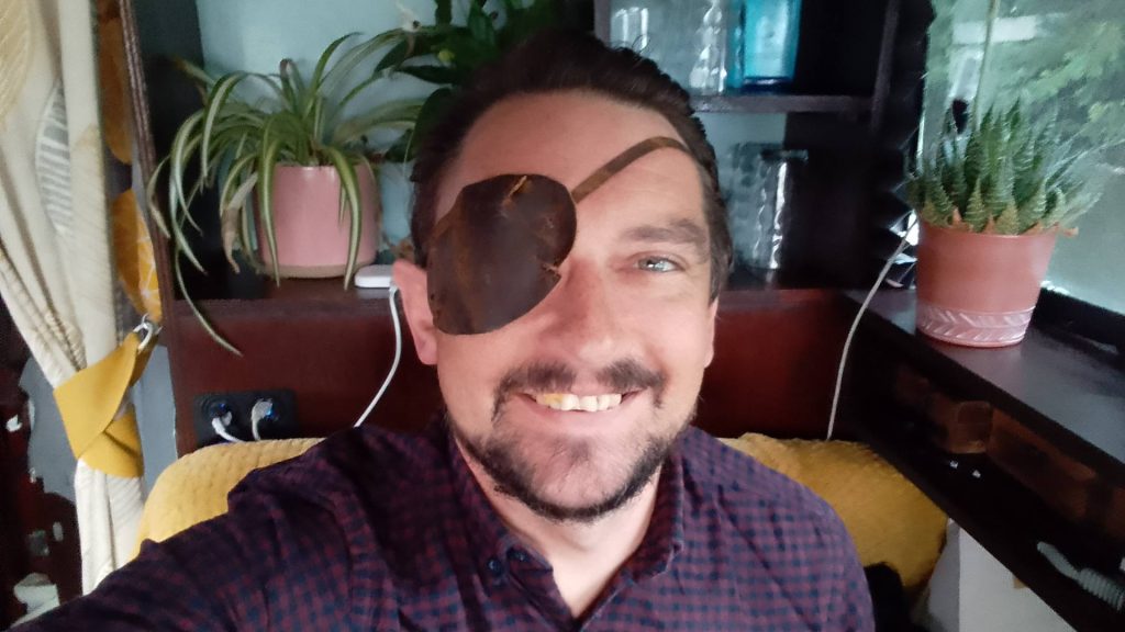A man with an eye patch sitting in a houseboat