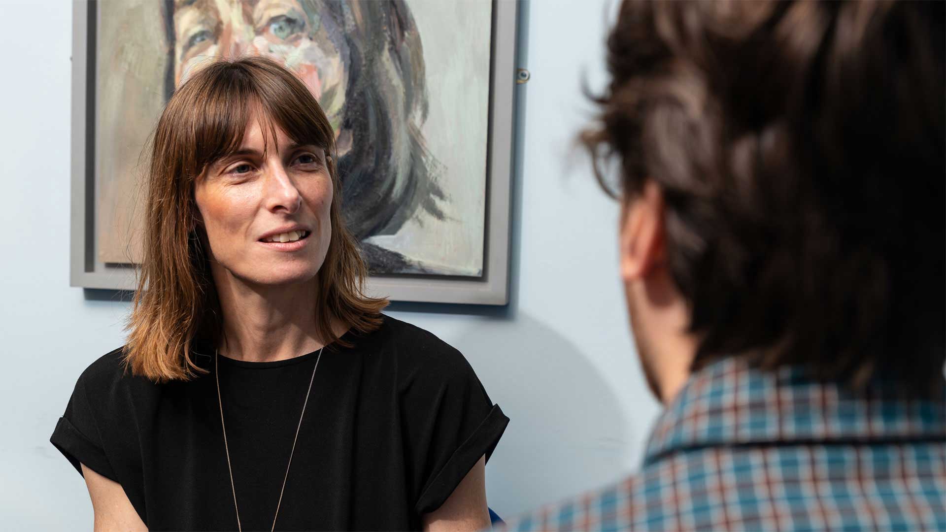 Two people in a counselling and wellbeing support session, the client looking away from the camera