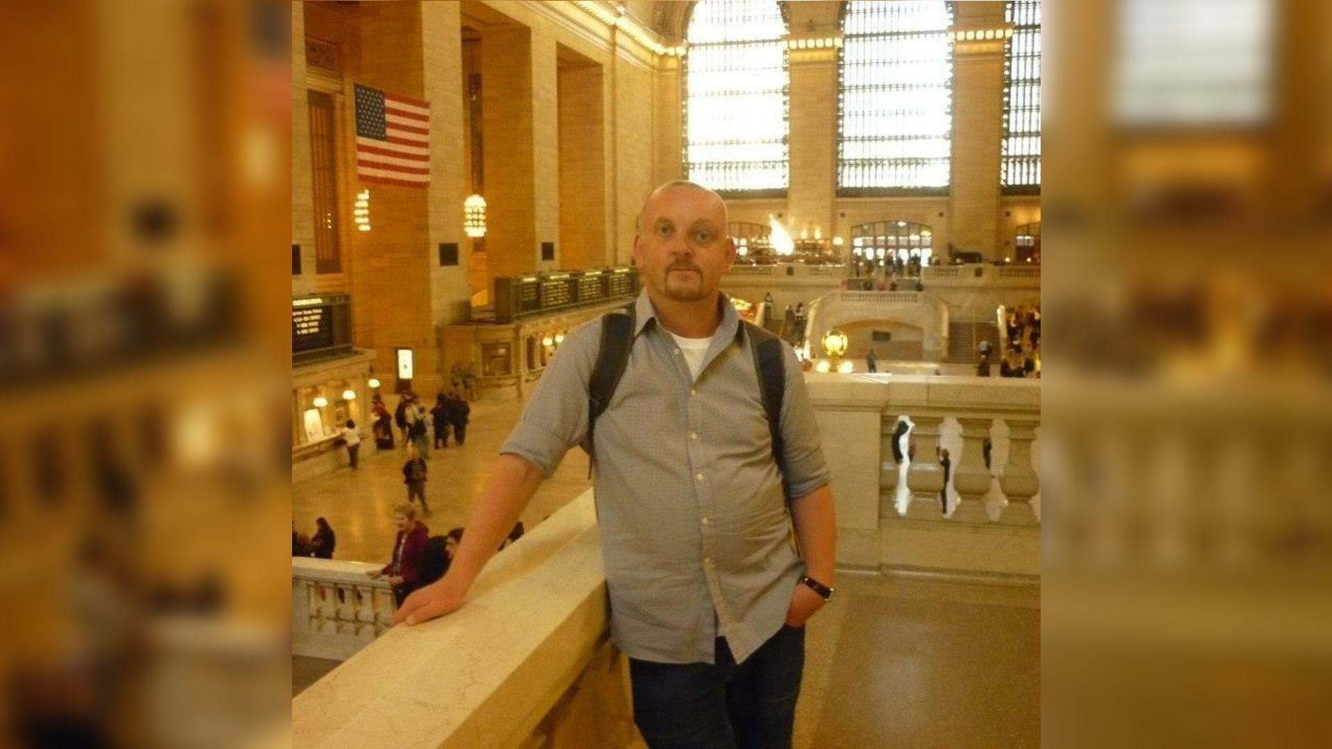 A man with a visible difference standing in Grand Central