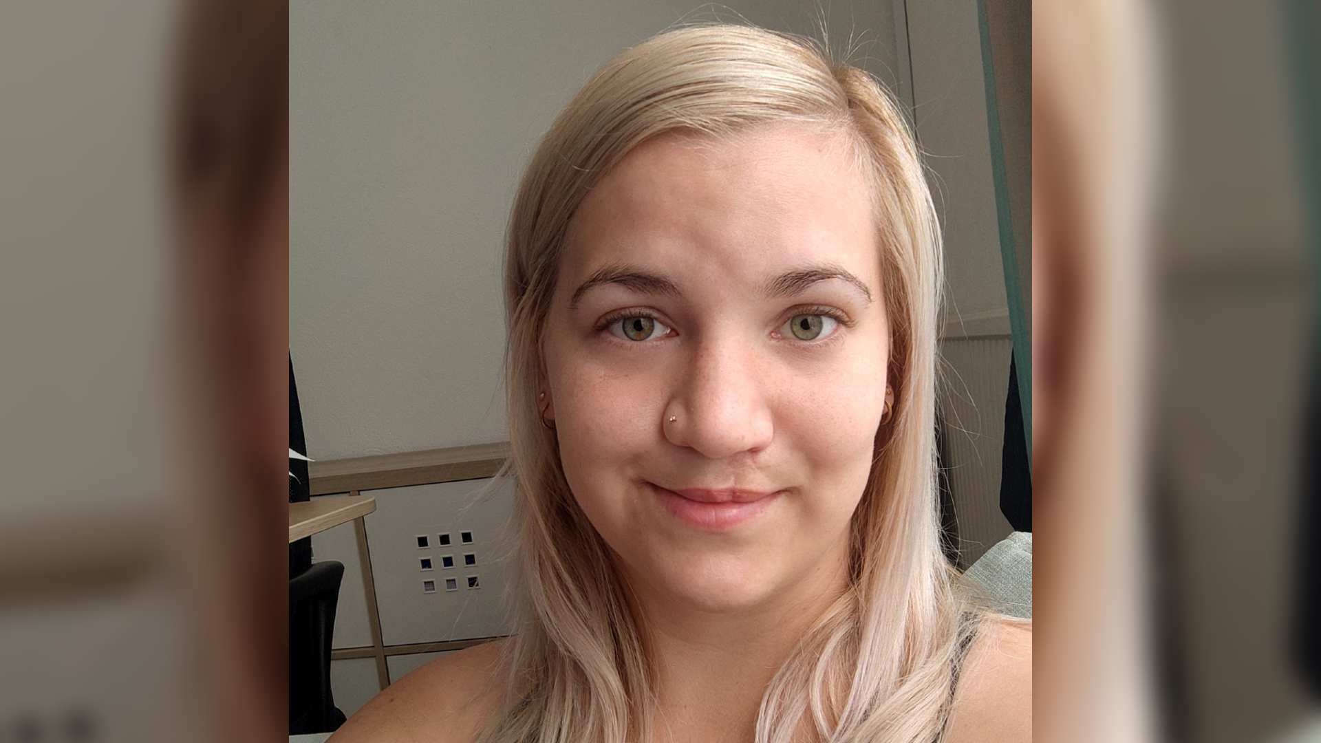 A blonde woman with a cleft scar smiles in a selfie