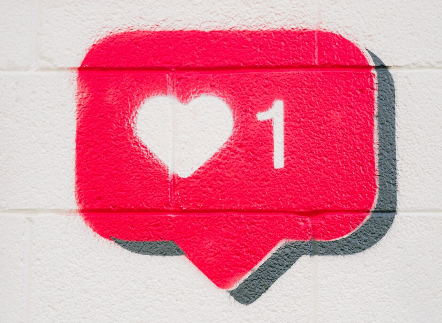 A like icon in a speech bubble on a brick wall