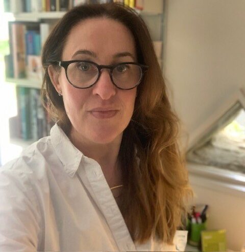 Louise Wright CEO of Changing Faces wearing glasses and a white shirt