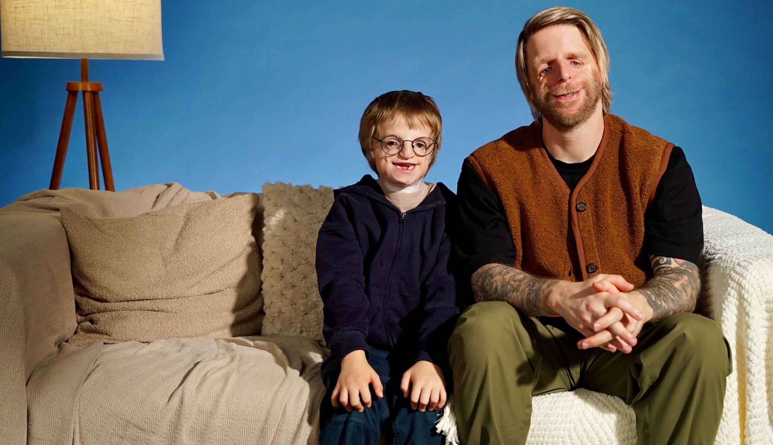 Jono and William sat on the sofa for Changing Faces Christmas campaign 2025