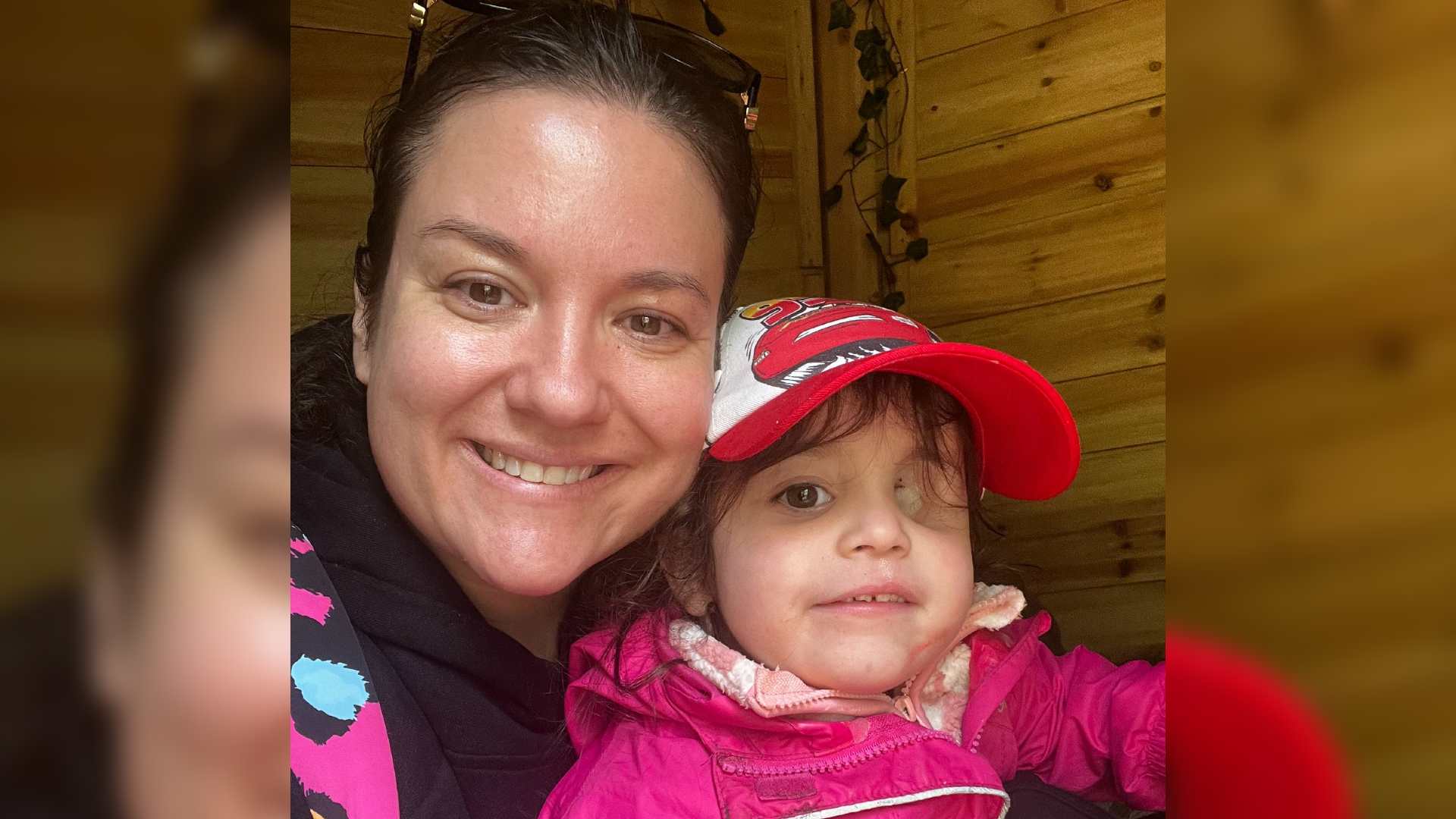 A selfie of Megan with her daughter Nuala. Nuala is missing an eye following cancer. They both smile at the camera.