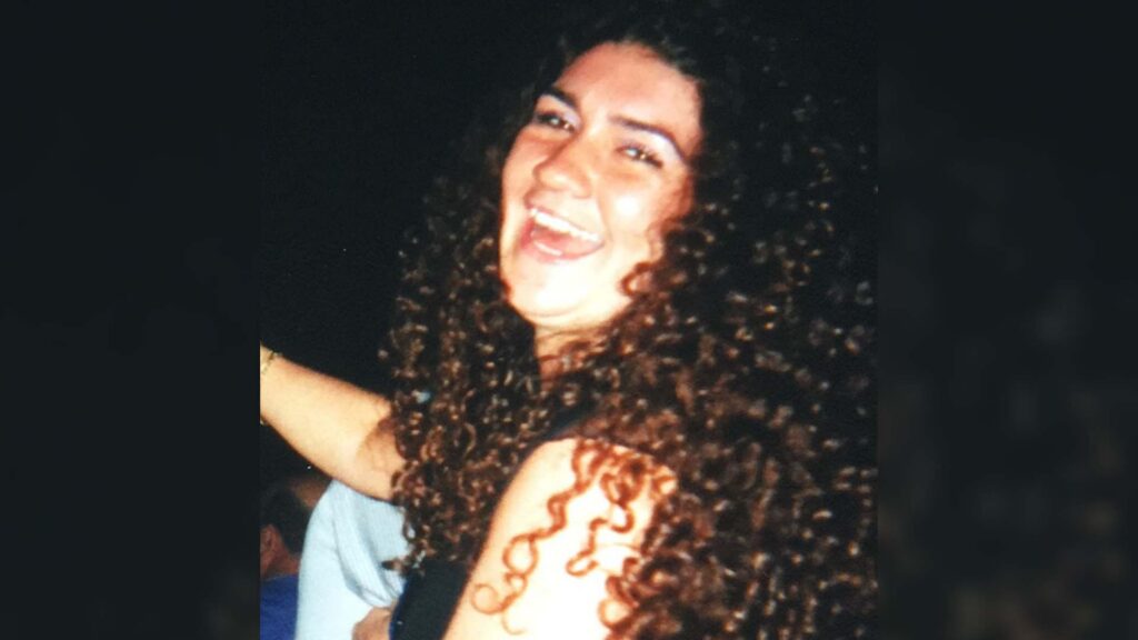 A photo of Tracey before she developed alopecia areata. She has long dark curly hair.