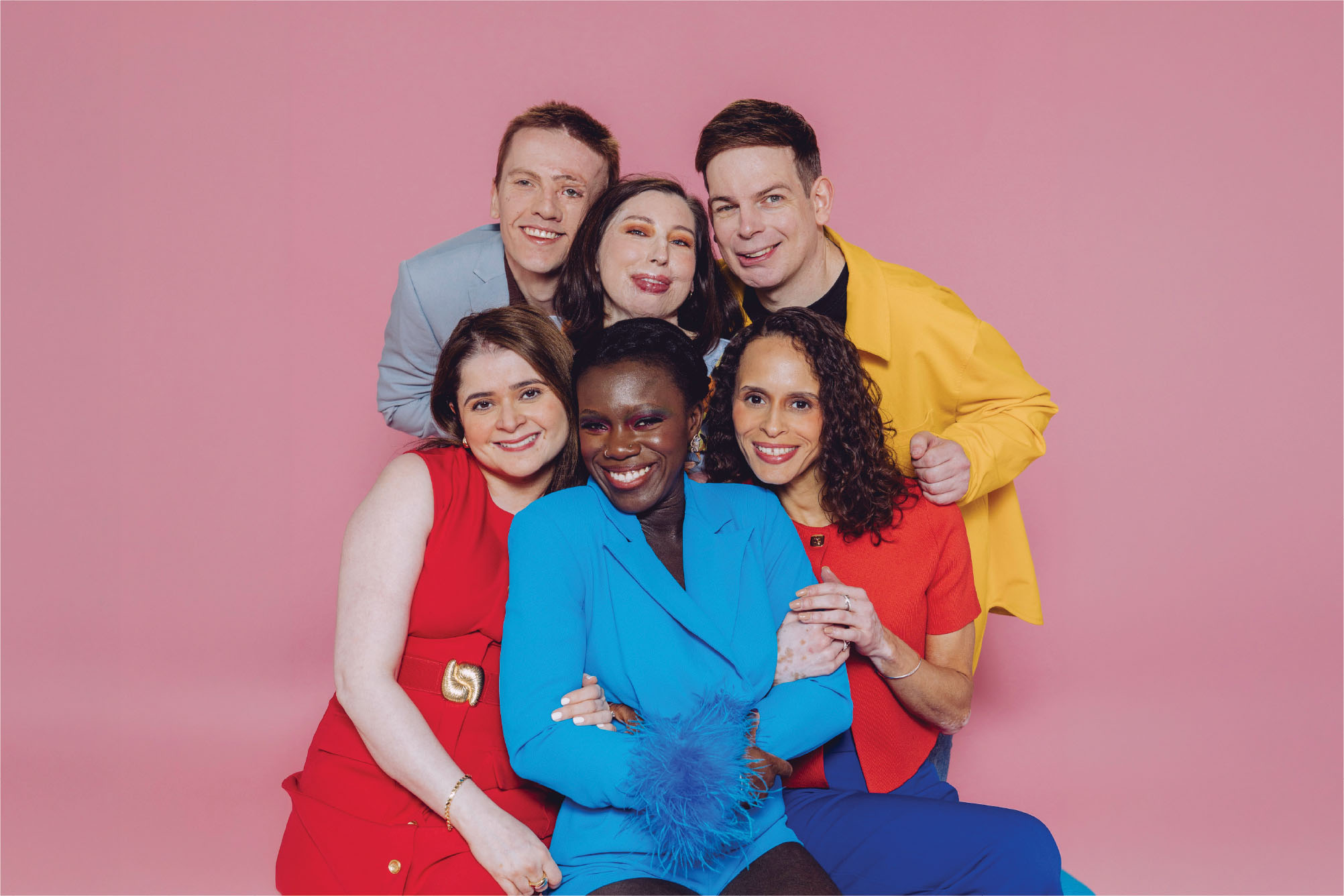 Six people with a visible difference are grouped together in bright clothes