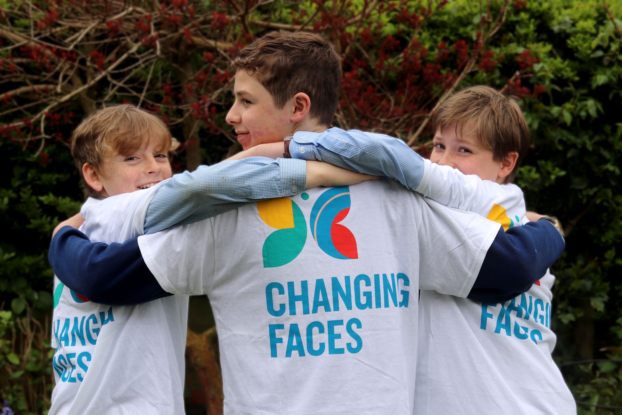 three lads in agroup with changing faces t-shirts on