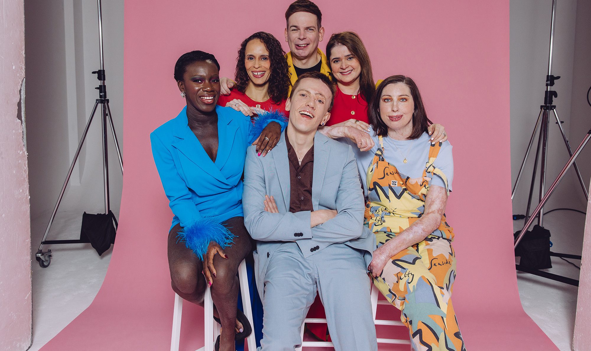A group of people with visible differences in front of a studio set