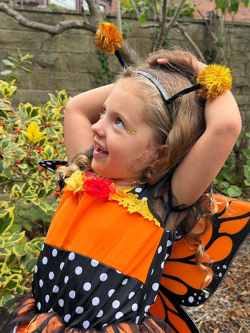 Lola smiling whilst looking up, dressed up for Halloween